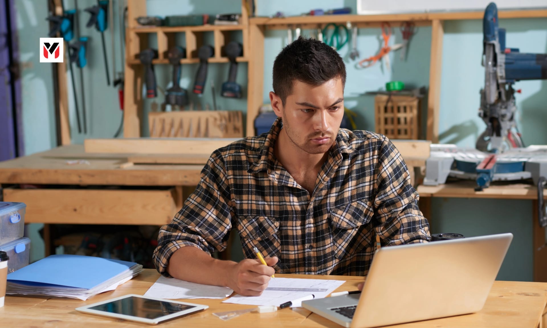 Small business owner at a laptop on the Udyam portal in a shop office